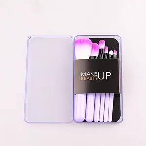 Detail of five portable purple makeup brushes with gradient bristles in a clear storage box