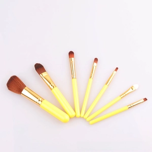 Detailed close-up of 7-piece makeup brush set featuring yellow handles and brown bristles