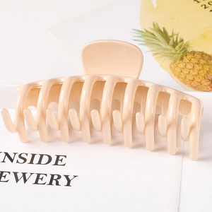 Macro view of large beige keel claw clip showing the glossy resin finish and prong detail
