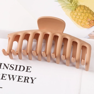 Top view of a matte khaki large hair claw clip on a minimalist lifestyle magazine background