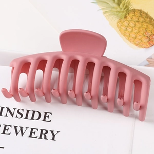 Detail view of large pink matte hair claw clip with bifurcated design on white background