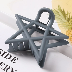 Macro detail of star shaped matte hair claw clip in a dusty blue finish for women