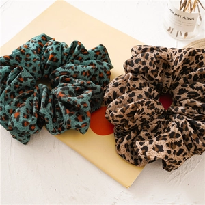 Detail of leopard print scrunchies in teal and beige on a stylish display card