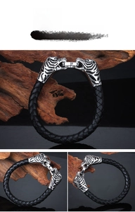 Detailed close-up of tiger head hardware on a black braided leather bracelet for men