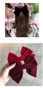 Detail of elegant velvet bow hair clips in black and wine red showing soft texture