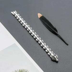 Detailed view of silver stainless steel dragon bone bracelet with wolf head clasp