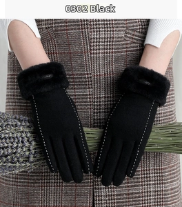Close-up of black thermal gloves with faux fur trim and white stitching holding lavender