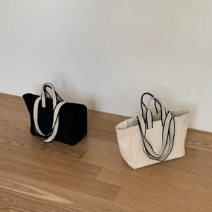 Minimalist canvas tote bags in black and beige with stylish striped handles