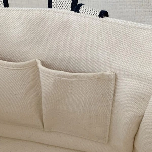Spacious canvas tote bag with striped handles and dual interior organizer pockets