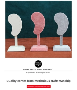 Three velvet ear-shaped earring display stands in white, pink, and grey colors
