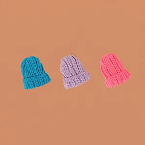 Trois bonnets en tricot unis pour enfants en bleu, violet et rose pour l'hiver