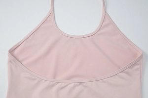 Detail of light pink halter neck top showing the U-neckline and fine stitching texture