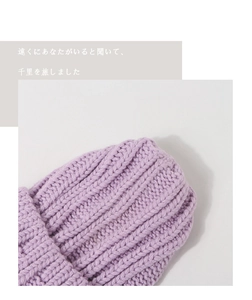 Vue détaillée du tricotage à grosses mailles d'un bonnet d'hiver violet pour enfants