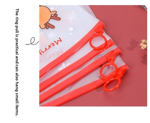 Macro detail of red ring zipper pull on festive Christmas themed clear stationery pouch