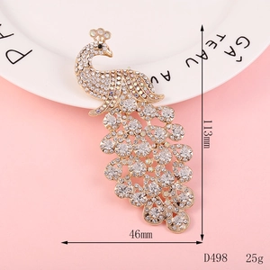Detailed view of peacock rhinestone brooch with dimensions 113x46mm on white plate