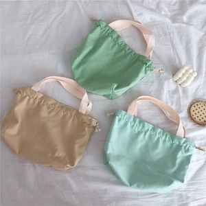 Minimalist canvas drawstring tote bag with cotton handles in pastel green and khaki colors
