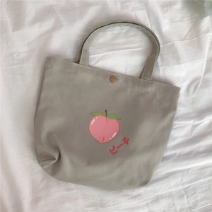 Nahaufnahme eines süßen Pfirsichdrucks auf einer grauen Segeltuchtasche.