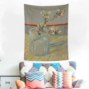 Van Gogh Almond Blossoms tapestry hanging on a white wall above a modern armchair