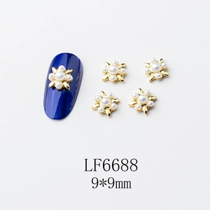 Détail de bijoux d'ongles dorés de 9 mm avec grande perle centrale et six petites perles