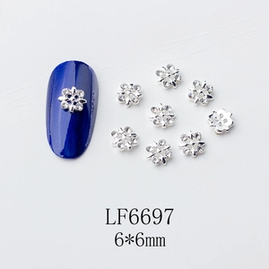 Détail de charmes à ongles en forme de fleur d'argent à cinq pétales avec strass