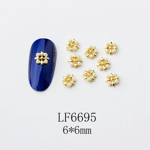 Vue détaillée de fleurs dorées pour ongles avec perles de 6x6mm sur fond bleu