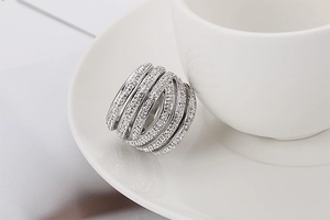 Macro detail of silver multi-layered wrap ring with sparkling zircon pavé on white ceramic