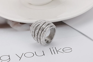 Macro view of a silver multi-layer intertwined wide band ring with pavé-set white zircons
