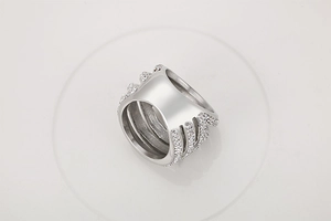 Detailed close-up of a multi-layer silver wide ring with micro-pave crystals on grey background