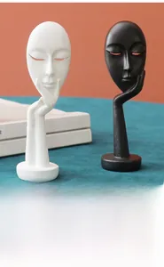 Close-up of minimalist black and white abstract face mask sculptures with matte resin finish