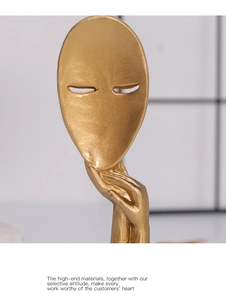 Detail of golden abstract thinker mask sculpture with matte texture and minimalist design