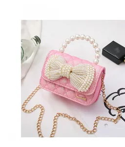 Detail of pink glitter mini bag with large pearl bow and elegant pearl top handle