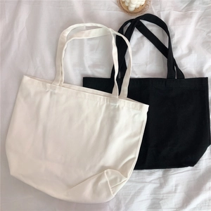 Λεπτομέρεια flat lay που δείχνει μαύρες και μπεζ υφασμάτινες τσάντες σε υφασμάτινο φόντο