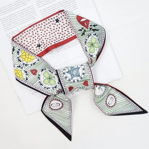 Detail showing colorful satin silk scarf with clover and heart patterns on a magazine