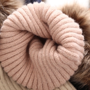 Detalle de punto rosa y pompón de piel sintética para gorro de invierno de bebé