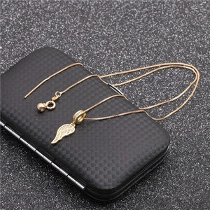 Golden necklace with angel wing pendant set with zircons on a black textured box