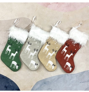 Detailed view of four linen Christmas stockings with reindeer patterns and fur cuffs