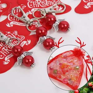 Detail view of silver angel wing keychains with red pearls and festive gift bags
