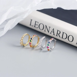 Macro detail of S925 silver huggie earrings with colorful stones and clear cubic zirconia