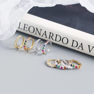 Macro shot of gold and silver plated hoop earrings with colorful inlaid cubic zirconia