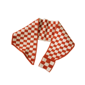 Orange and beige checkered knit scarf for women shown flat on a white background