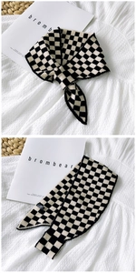 Macro detail of black and white checkerboard knit scarf with soft fabric texture