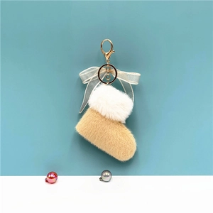 Detail of plush Christmas boot keychain with sheer bow and golden metal lobster clasp