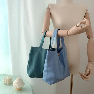Close-up of canvas tote bags hanging on a wooden arm in a cozy Nordic home setting
