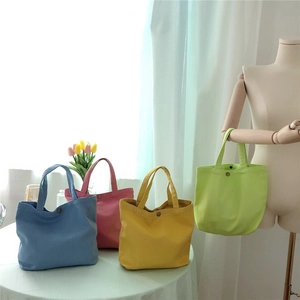 Detail of colorful canvas tote bags with secure metal snap button closures