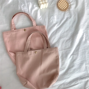 Detail view of pink twill canvas tote bags with vintage magnetic snap buttons