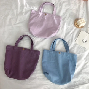 Detailed top view of three canvas tote bags in morandi colors with golden magnetic snaps