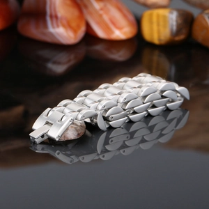 Polished silver stainless steel watch band with semi-circular links on black mirror