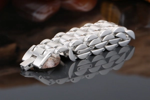 Macro shot of silver brushed stainless steel watch strap showing detailed link structure