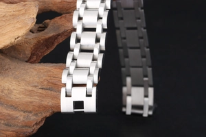 Detailed close-up of brushed stainless steel chain link bracelet on rustic wood