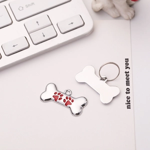 Zinc alloy bone-shaped dog tag with red paw print and ring for pet identification